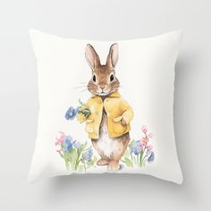 a pillow with a watercolor painting of a rabbit wearing a yellow jacket and flowers