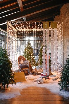 a room decorated for christmas with lights and decorations on the walls, along with trees