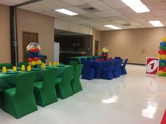 an empty banquet hall with tables and chairs set up for a balloon filled birthday party