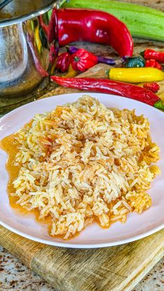 a white plate topped with rice covered in gravy on top of a wooden cutting board