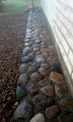 there is a brick wall and some rocks on the ground