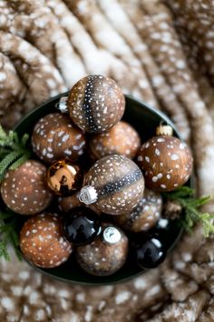 a bowl filled with lots of different types of ornaments on top of a fur covered surface