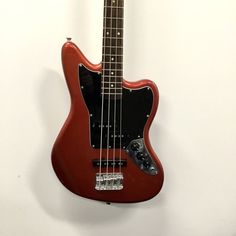 an electric bass guitar hanging on the wall