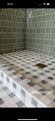 a tiled shower with a drain in the middle