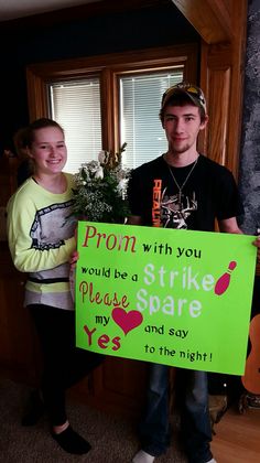 two people holding a sign that says prom with you would be a strike spare and say yes to the night