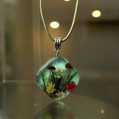 Elevate your jewelry collection with our exquisite Handmade Necklace, featuring real pressed flowers. Each necklace is a unique piece of art, meticulously crafted to capture the delicate beauty of nature.  Features: Unique Design: Each necklace is one-of-a-kind, showcasing different combinations of real pressed flowers. Quality Materials: Made with high-quality resin, ensuring durability and clarity. Adjustable Chain: Comes with an elegant, adjustable chain to suit any neckline. Eco-Friendly: All flowers are ethically sourced and preserved without chemicals. Perfect for: Nature lovers Special occasions like birthdays, anniversaries, or weddings Adding a touch of elegance to everyday outfits Dimensions Model 1: Pendant: 2.2cm*2.2cm/0.86in*0.86in Suede cord length: 43cm+5cm adjustable chain/ Delicate Green Jewelry With Birth Flower, Delicate Green Birth Flower Jewelry, Nature-inspired Green Jewelry With Birth Flower, Nature-inspired Flower Pendant Jewelry For Mother's Day, Unique Jewelry With Flower Charm, Nature-inspired Birth Flower Jewelry As Gift For Mom, Nature-inspired Birth Flower Jewelry For Mom, Round Pressed Flowers Jewelry For Birthday Gift, Spiritual Style Necklace With Pressed Flowers As A Gift