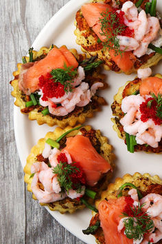 small appetizers are arranged on a white plate with garnishes and herbs