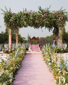 an outdoor ceremony with flowers and greenery on the aisle leading up to the altar