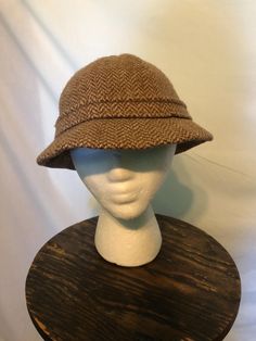 1980s Kangol made in England brown herringbone bucket hat: This Kangol hat is wool. It is labeled a size medium. The circumference at the inner band is 21 in. Retro Winter Bucket Hat With Curved Brim, Retro Curved Brim Bucket Hat For Winter, Retro Brimmed Bucket Hat For Winter, Retro Brimmed Winter Bucket Hat, Winter Retro Curved Brim Bucket Hat, Winter Retro Brimmed Bucket Hat, Adjustable Wool Bucket Hat, Vintage Hat Bands For Fall, Classic Brown Bucket Hat With Short Brim