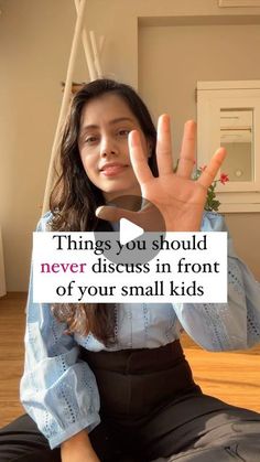 a woman sitting on the floor with her hand up to say, things you should never discuss in front of your small kids