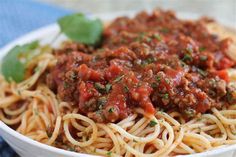 a white bowl filled with spaghetti and meat sauce