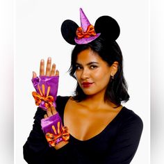 a woman in black shirt holding up purple and orange ribbon with mickey mouse ears on it