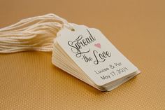 some white tags with the words spread the love written on them are next to a ball of twine