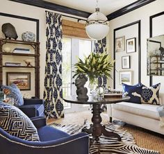 a living room with blue and white furniture, zebra print rugs and pictures on the walls