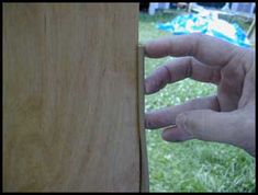 a person holding their hand out to the side of a wooden board