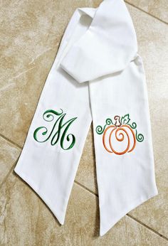 two white towels with monogrammed pumpkins on them