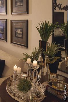 a living room with candles and pictures on the wall