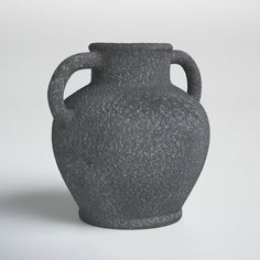 a large gray vase sitting on top of a white table