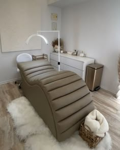 a large tan leather bed sitting on top of a hard wood floor next to a white dresser