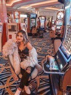 a woman sitting in a chair next to slot machines