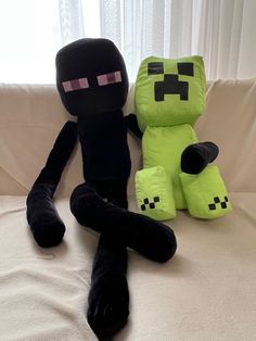 two stuffed toys sitting on top of a couch