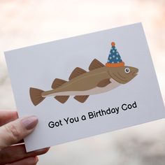 someone holding up a birthday card with a fish on it