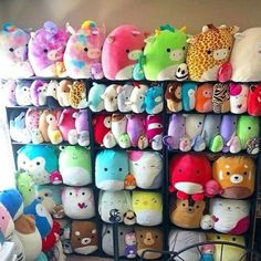 a room filled with lots of stuffed animals next to a wall full of other stuffed animals