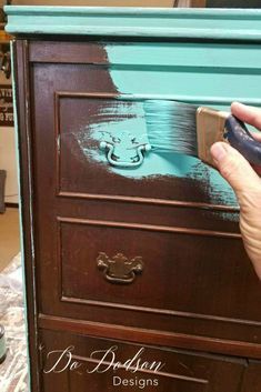 someone is painting an old dresser with blue paint