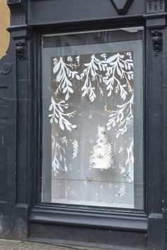 a storefront window with an ornamental pattern on it's glass and frosting