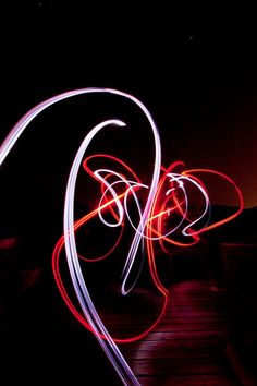 a blurry photo of some lights on a wooden walkway in the dark with long exposure