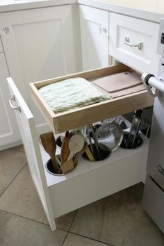 an open drawer in the middle of a kitchen