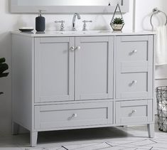 a bathroom vanity with two sinks and a mirror on the wall above it is shown