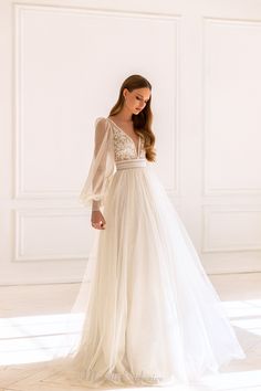 a woman in a white wedding dress standing on the floor with her back to the camera