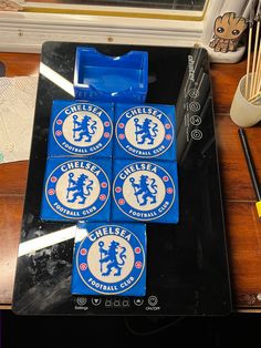 four coasters sitting on top of a wooden table next to an electronic mouse and keyboard