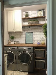 a washer and dryer in a small room with open shelves on the wall