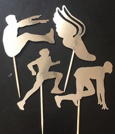 four cupcake toppers made to look like the silhouettes of people in different poses