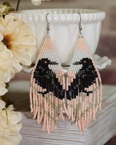 pink and black beaded earrings with flowers in the background