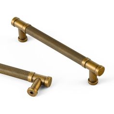 two brass colored handles on a white background