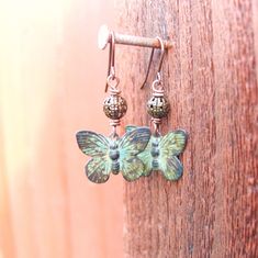 "I hand patina these beautiful metal butterfly to create a green verdigris coloring. The green verdigris patina has been sealed with lacquer to insure a very durable finish. A simple 5mm antique brass filigree ball sit a top the sweet butterflies. They measure 1 ½\" from the top of the antique brass earrwires. The butterflies measure ¾\" in width. See more of my jewelry designs here: https://www.etsy.com/shop/JensBeadBox All my jewelry comes gift boxed with a bow ready for gift giving whether it Unique Green Butterfly Earrings, Green Adjustable Jewelry With Butterfly Charm, Green Bohemian Butterfly Jewelry, Bohemian Green Butterfly Jewelry, Nature-inspired Green Butterfly Jewelry, Green Butterfly Nature-inspired Jewelry, Pierced Green Copper Earrings, Green Copper Pierced Earrings, Vintage Green Patina Earrings