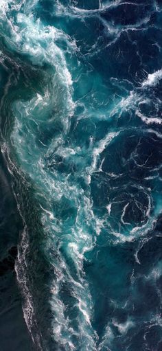 an aerial view of the ocean with waves and foamy blue water, from above