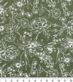 a green and white floral print fabric with flowers on it, as well as a ruler