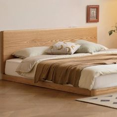 a large bed sitting on top of a hard wood floor next to a wall mounted clock