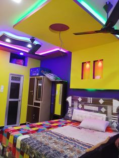 a bed room with a neatly made bed and colorful lights on the ceiling above it