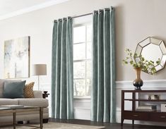 a living room filled with furniture and a window covered in blue drapes next to a coffee table