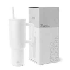 a white cup with a straw in it next to a cardboard box and the packaging