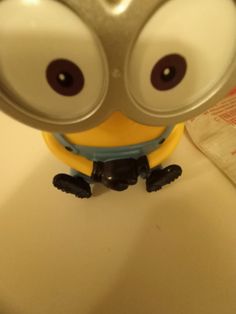 a minion with big eyes sitting on top of a counter