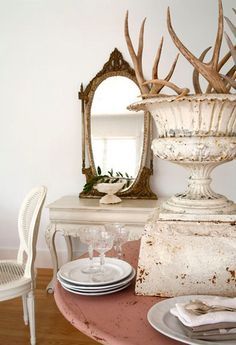 an old dresser with antlers on it and a mirror in the corner next to it