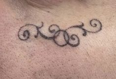 a close up of a person's neck with a tattoo on the side of their neck