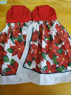 a red and white dress with poinsettis on it sitting on a table