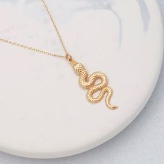 "Our new 14k Solid Gold Snake Necklace. A perfect gift for special occasions, or for yourself. Introducing our stunning 14K Solid Gold Snake Necklace, featuring a Large Snake Pendant that gracefully hangs on your neck. This exquisite Serpent Necklace is the perfect statement piece for any occasion, combining boldness and elegance in one design. Crafted from high-quality 14K Solid Gold, this necklace exudes luxury and durability. Elevate your style with this captivating Snake Necklace, a timeless addition to your jewelry collection. * Features of the Necklace * Gold Kt: 14K Solid Gold (stamped) * Available Gold Color: Yellow Gold, Rose Gold and White gold * Approx. Weight: 2.70 grams * Measurements: 28 mm by 12.5 mm * We offer free domestic shipping * All chains and metals used in these nec Gold Snake Necklace, Serpent Necklace, Large Snake, Largest Snake, Snake Pendant, Solid Gold Necklace, Evil Eye Ring, Snake Necklace, Gold Snake